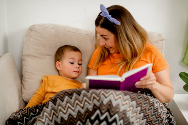 istock Woman with boy reading book 1223092481