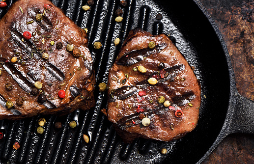 Barbecue grilled beef medallions in a cast iron griddle