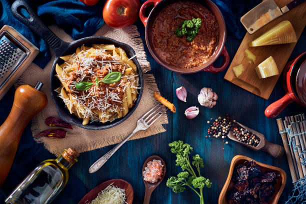istock Penne with Bolognese sauce in serving size casserole with ingredients in rustic pots 1223093357