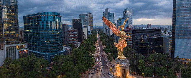 Vista aérea frontal de la estatua del ángel de la independencia en la Avenida Reforma con el bosque de Chapultepec al fondo photo