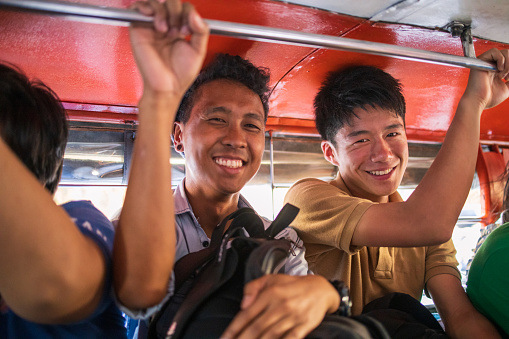 Asian friends riding jeepney in Philippines