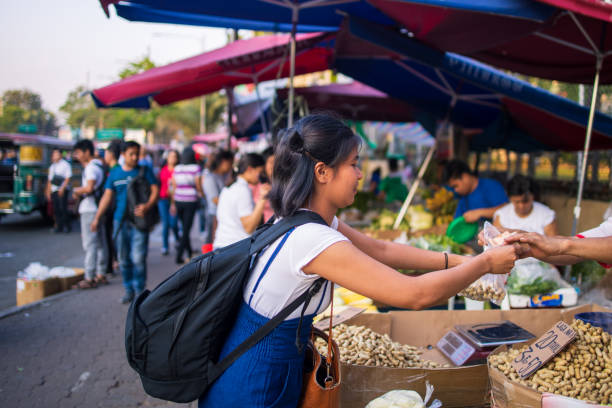 jovem asiática comprando comida em barraca de comida de rua - asian ethnicity philippines women beauty - fotografias e filmes do acervo