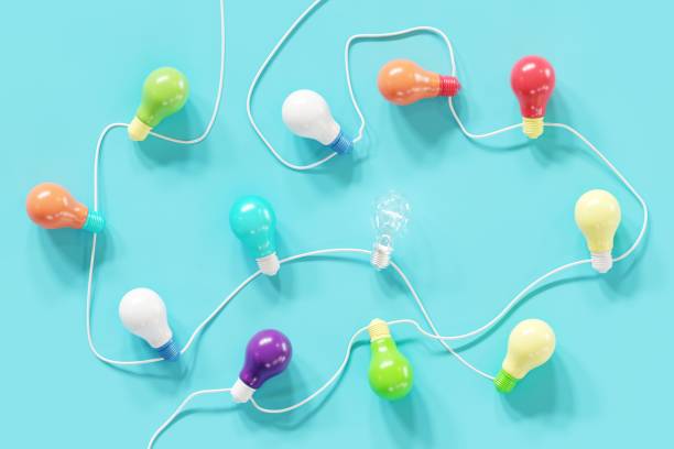 istock Outstanding Light bulb Glowing one among colorful light bulb on blue background Top view. 3D Render. Minimal concept idea. 1223101900
