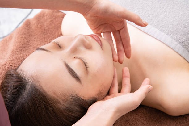 massaging the face of asian woman A female practitioner massaging the face of asian female patient aesthetician photos stock pictures, royalty-free photos & images
