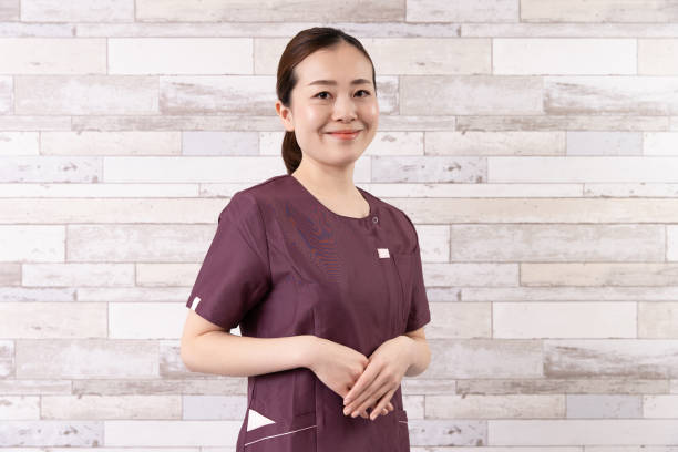 Asian young female practitioner at a beauty salon store Asian young female practitioner dressed in reddish brown clothes at a beauty salon store aesthetician photos stock pictures, royalty-free photos & images