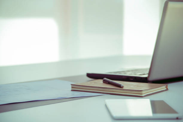 istock work from home, Classic note book and pen on a white modern business office desk table with notebook, laptop computer, and tablet with blank workspace for text input, interior design in calm concept 1223104257