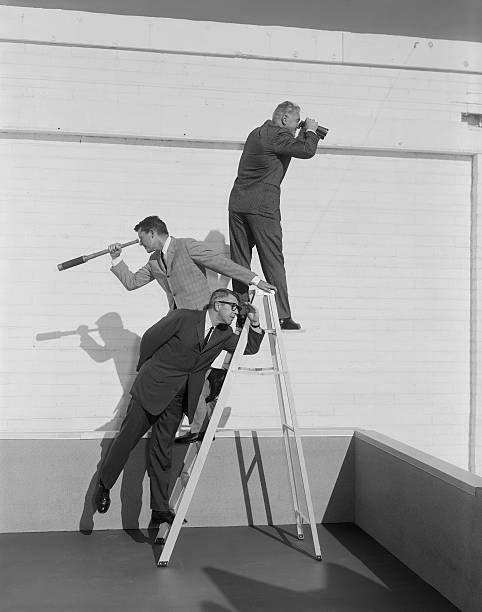 uomo in piedi sulla scala con binocolo e telescopio - historical person foto e immagini stock
