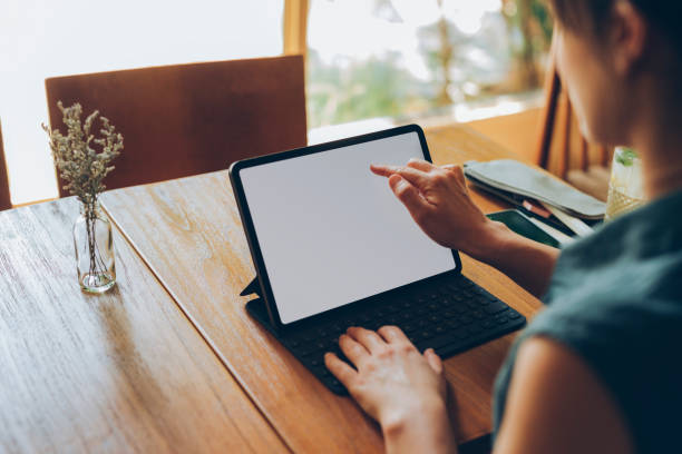 Working Remotely: Unrecognizable Woman Using her Tablet to Work at a Local Cafe