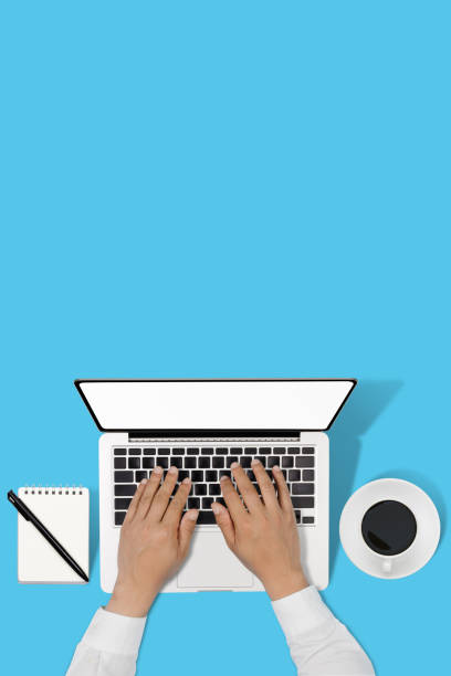istock businessman working with modern workplace with laptop on blue table, Man hand on laptop keyboard for work from home, Overhead view of businessman working  in office 1223111512