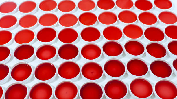 istock Set of clinical samples of red liquid in round plastic containers on a white surface 1223111704