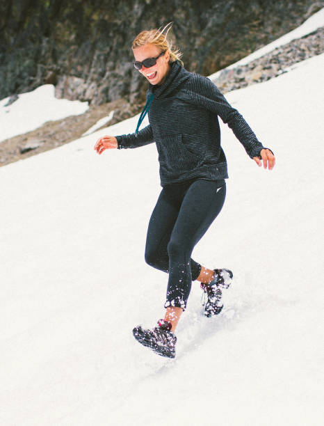 istock Happy woman glissading down a snow field 1223120732