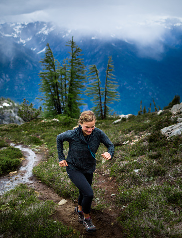 Healthy woman mountain trail running in the North Cascades in Washington State