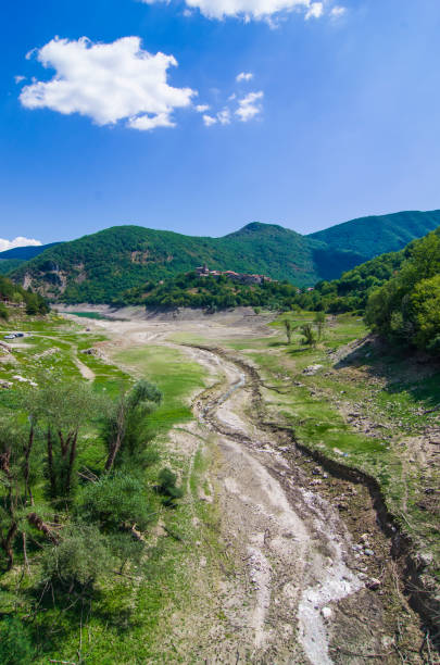 istock drought and temperature rise catastrophe, dry river and town without water. 1223120983