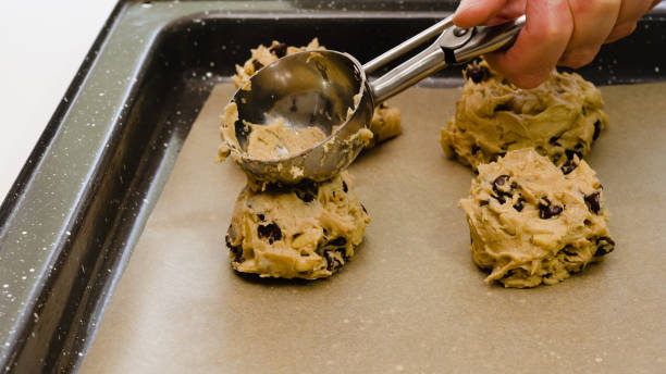 istock Chocolate Chip Cookies recipe. Placing cookie batter on a baking sheet, close up on white background, 1223124653