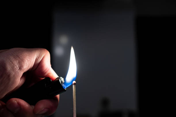 istock Lighting a match stick with a lighter isolated on a black background 1223124748