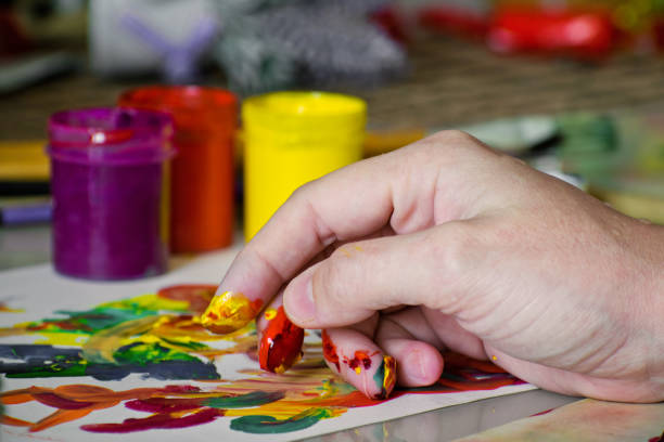 mão de uma garota misturando cores com dedos para pintar. pintura abstrata com gouache. pintura de dedo - tempera painting paint art bottle - fotografias e filmes do acervo