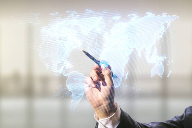 Double exposure of man hand with pen working with abstract digital world map on blurred office background, research and strategy concept