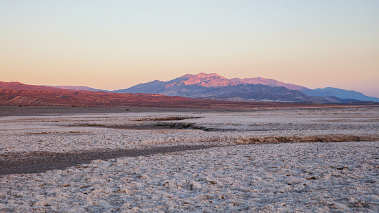 Moody Panorama of Death Valley Salt Basin in atmospheric moody sunset twlight. Death Valley's Badwater Basin is the Point of the lowest elevation in North America at 282f - 86m below sea level. Death Valley National Park, Eastern California, USA, North America