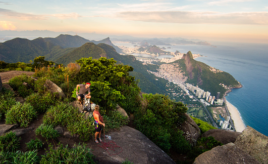 Mountain climbers sorting their gear and coiling ropes\n above Rio De Janeiro Brazil