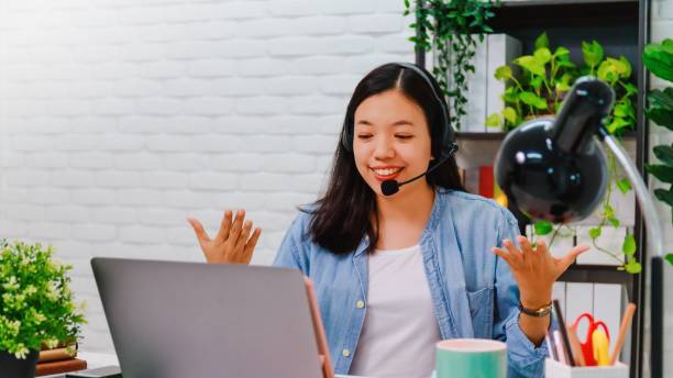 la donna d'affari asiatica lavora da casa con il computer portatile sul tavolo con riunioni online e videoconferenze. concetto di distanziamento sociale per fermare la malattia diffusa del virus corona. - contemporary domestic room sparse indoors foto e immagini stock