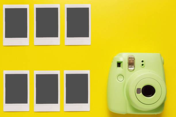 현대 녹색 폴라로이드 카메라, 노란색 배경에 사진. 상단보기, 부드러운 최소한의 플랫 레이 스타일 구성. 관광 개념. 텍스트에 대한 복사 공간 - shot glass flash 뉴스 사진 이미지