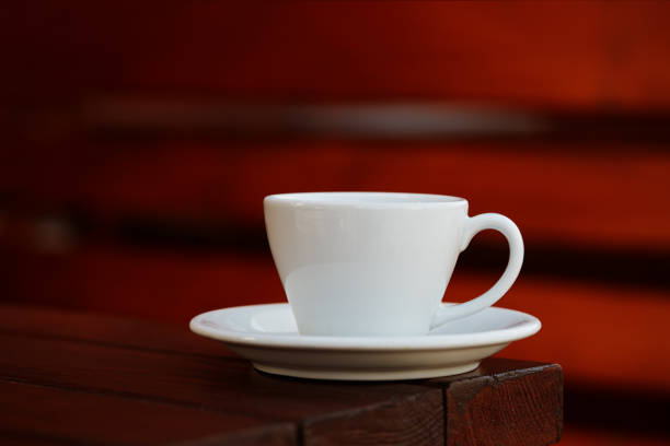 A close-up of a vintage floral teacup filled with tea, placed on a saucer with traditional Eid cookies (Kahk) in the background. Warm, cozy atmosphere perfect for Ramadan and festive tea time moments.