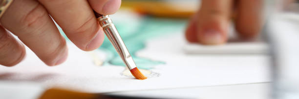 istock Male hand making drawing with watercolor brush 1223137831
