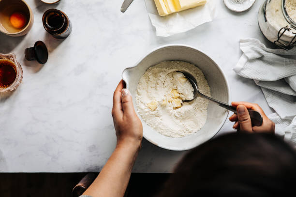 frau bereitet fruchtkuchenteig mit mehl und butter zu - kuchen backen stock-fotos und bilder