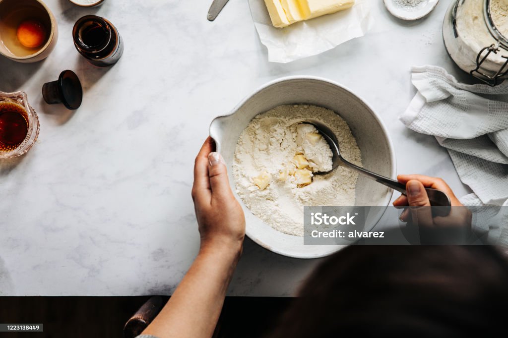 Woman preparing fruit pie dough with flour and butter Directly above photograph of a woman preparing fruit pie dough for a german lattice fruit pie Baking Stock Photo