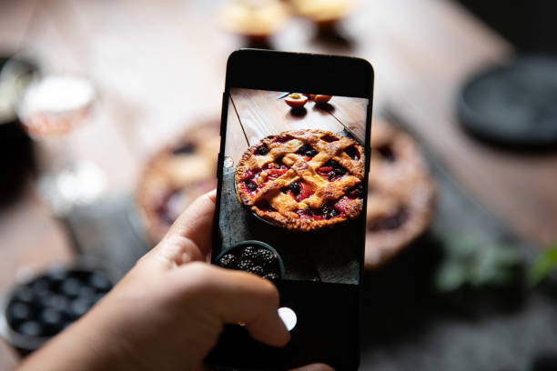 Photographing a lattice fruit pie with a smart phone Woman using her smart phone to photograph a typical german lattice fruit pie sweet pie photos stock pictures, royalty-free photos & images