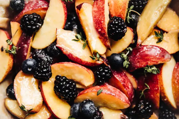 Photo of Close up of marinated fruit and thyme for a fruit pie