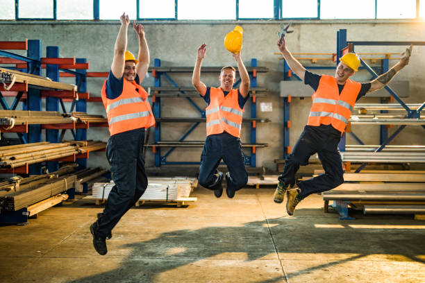 istock Happy metal workers having fun while jumping in aluminum mill. 1223139312