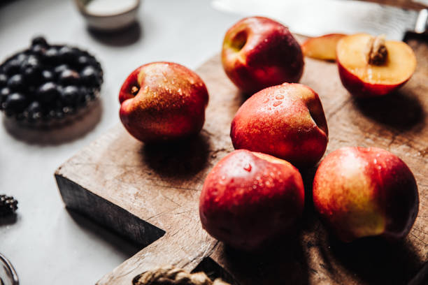 fresh ripe nectarines on a wooden cutting board - baking traditional culture studio shot horizontal imagens e fotografias de stock