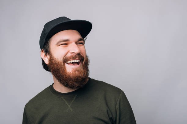 istock Cheerful bearded man wearing a cap with a large smile is looking aside. 1223139365