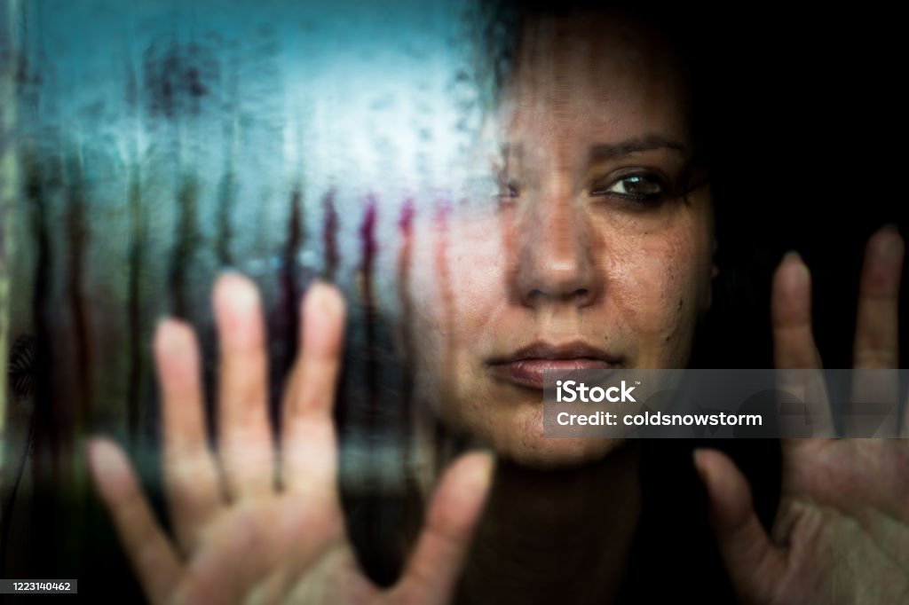 Депрессивная женщина, смотря в дождливое окно - Стоковые фото Бытовое насилие роялти-фри