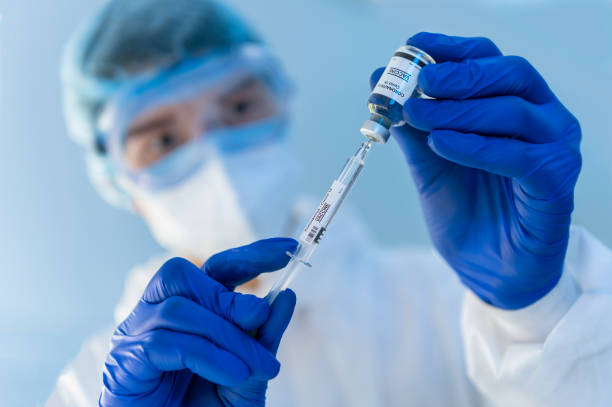 istock virus experts discover coronavirus covid 19 vacinne holding  syringe labelled coronavirus covid 19 in laboratory 1223140888