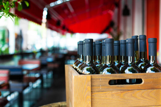 una scatola di legno piena di bottiglie di vino. festa in banca in un ristorante all'aperto - wine bottle bottle burgundy wine foto e immagini stock