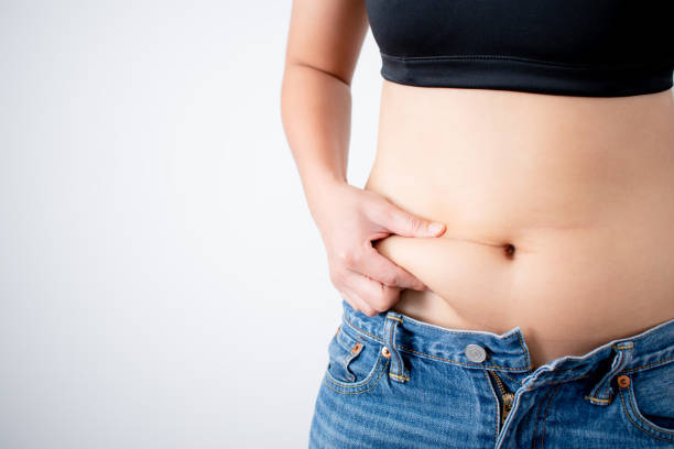 istock Close up of a woman's hand that grabs belly fat. With copy space. 1223145932