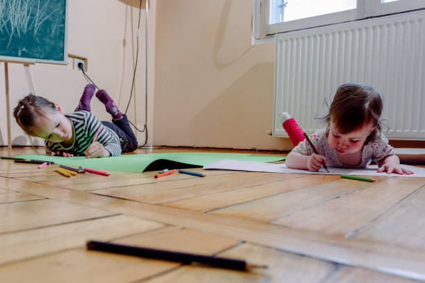 istock Sisters lying on the floor at home and drawing 1223148904