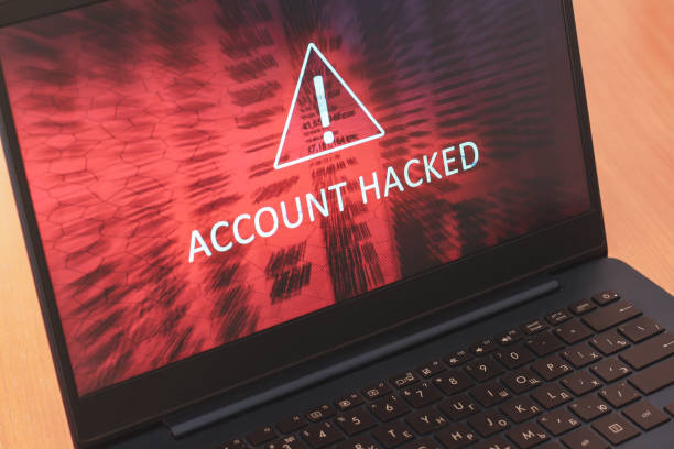 istock Laptop screen concept with white text Account hacked on red abstract background. Warning triangular sign with exclamation mark symbol. Horizontal. 1223148976