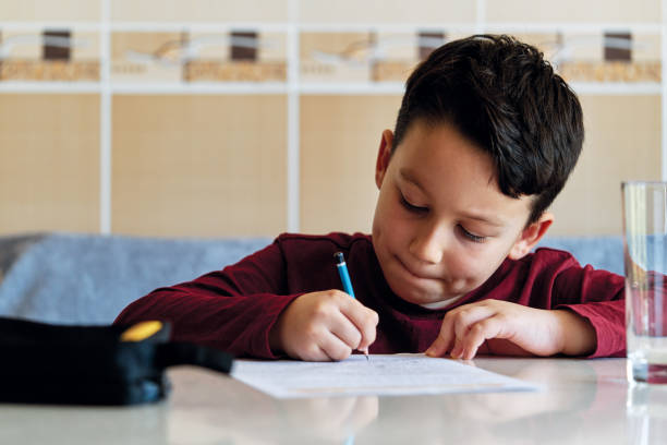 istock 6-7 years old child making homework at home. 1223152041
