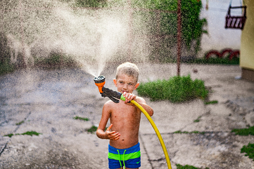 Photo of a boy splashing in the yard.