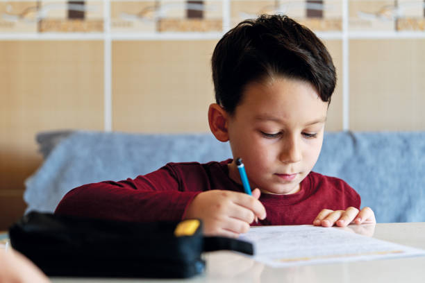 istock 6-7 years old child making homework at home. 1223152479