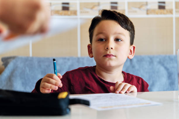 istock 6-7 years old child making homework at home. 1223152839