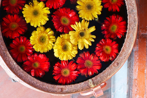 Water with jasmine flower, marigold petals and rose petals in silver bowl. Thai tradition, Songkran festival concept