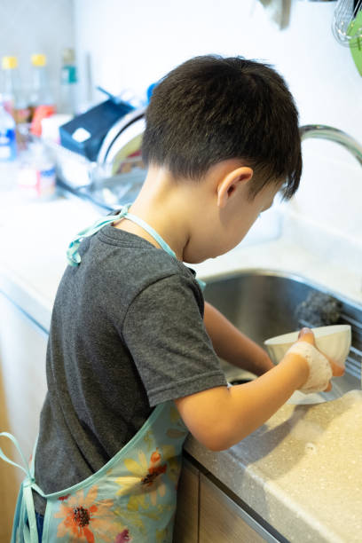 istock A boy helping his mother to wash dishes 1223156175