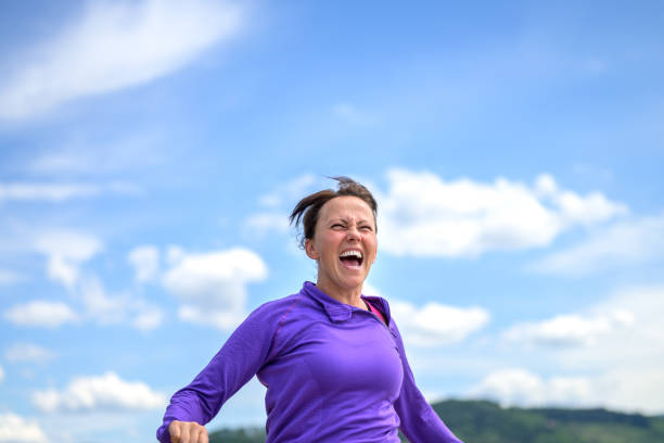 istock Happy vivacious woman laughing as she jogs 1223156368