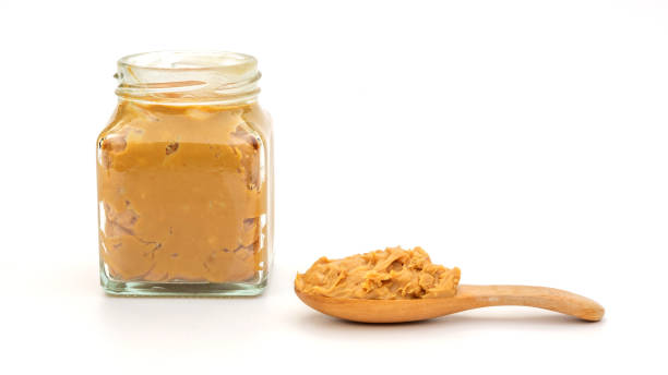 istock Peanut butter in a spoon and bottle on a white background. 1223156408