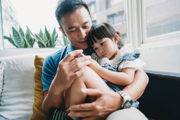 istock Father and daughter using a mobile phone together sitting on the sofa at home 1223157592