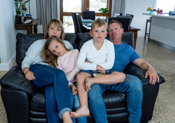 istock Coronavirus lockdow. Bored family watching tv helpless in isolation at home during quarantine COVID 19 Outbreak. Coronavirus lockdown and social distancing impact in mental health concept. 1223157761